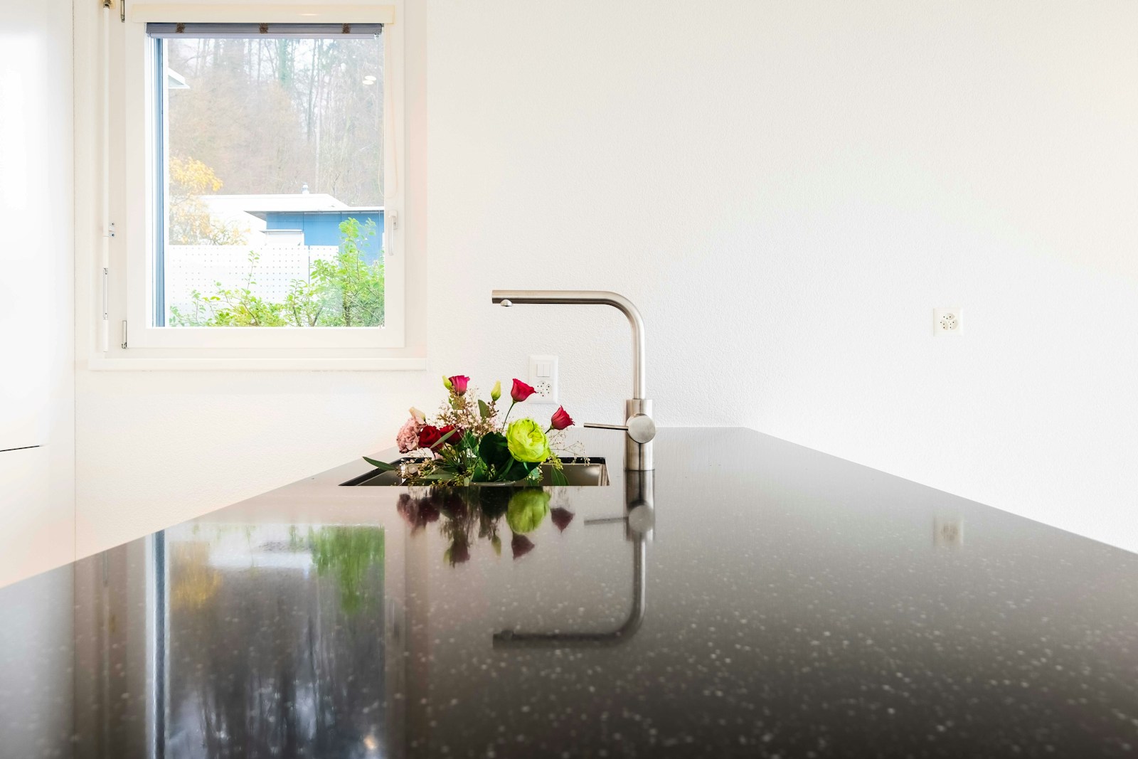 red and white flowers in clear glass vase on table